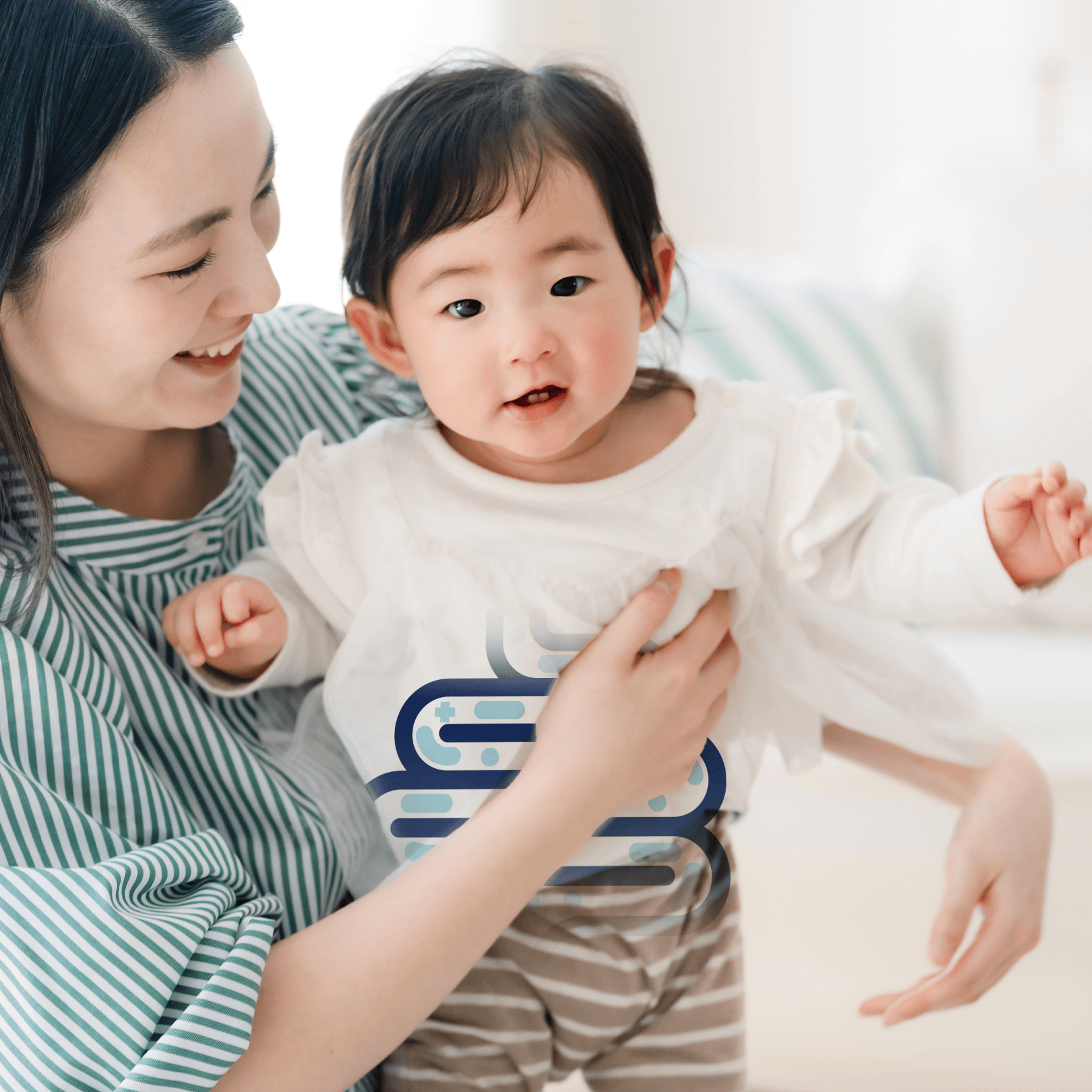 Woman holding a baby wearing a white shirt with blue graphics on a light background