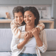 Woman and child hugging on a couch in a kitchen